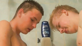 2 young boys having a cockfight in the shower